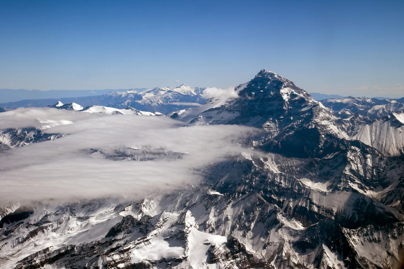 Aconcagua rising above a sea of clouds among the snowy ridges of the Andes