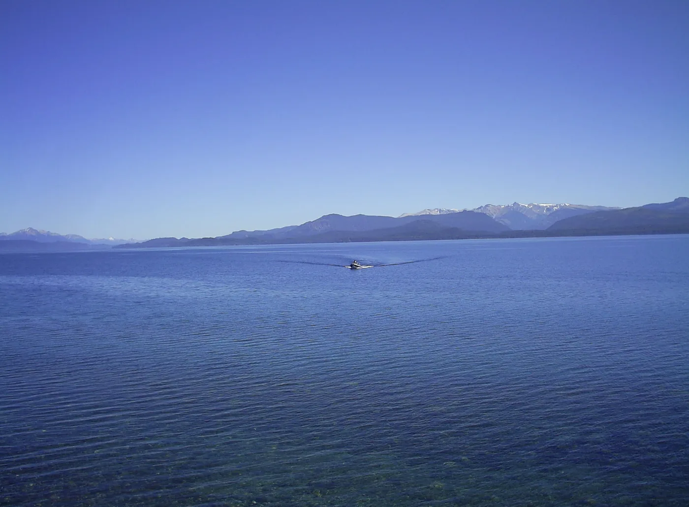 The calm blue water of Lake Nahuel Huapi with the Andes on the far shore